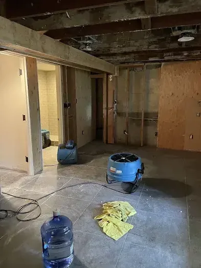 Room opened up to the ceiling joists with an air mover running