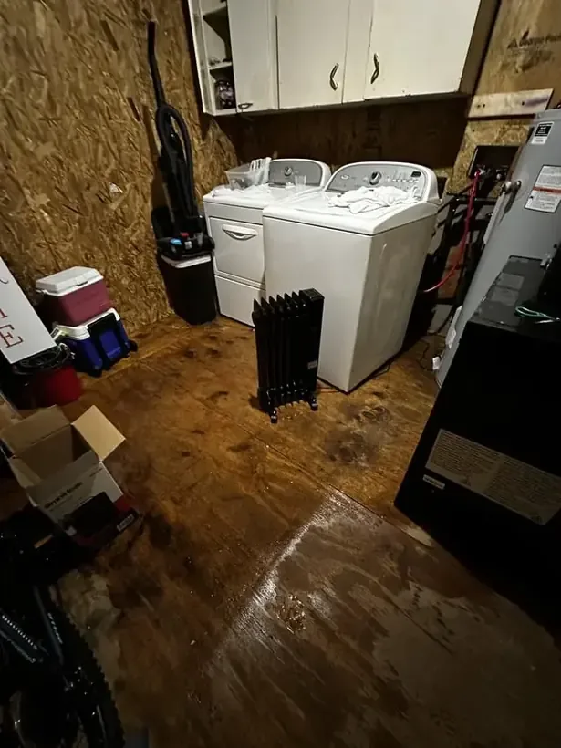 Water from a leaking washing machine hose spreading across the floor