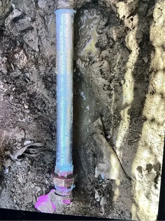 Broken, corroded supply pipe exposed after it leaked into the wall around it