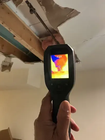 Thermal imaging camera checking an opened, water damaged ceiling