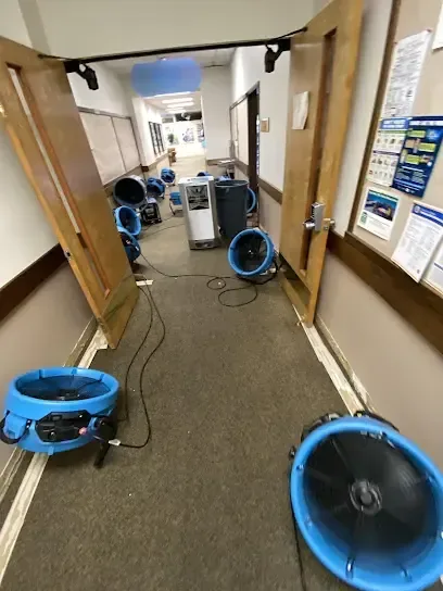 Air movers drying the floor of an office after a water loss