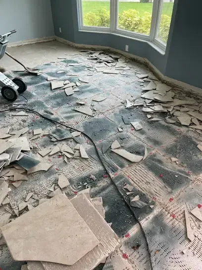 Floor tile broken out across a concrete slab to reach a leak below